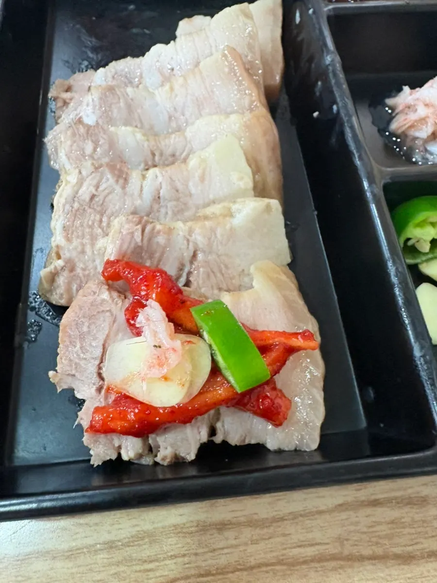새우젓과 무절임을 곁들인 수육 한 점