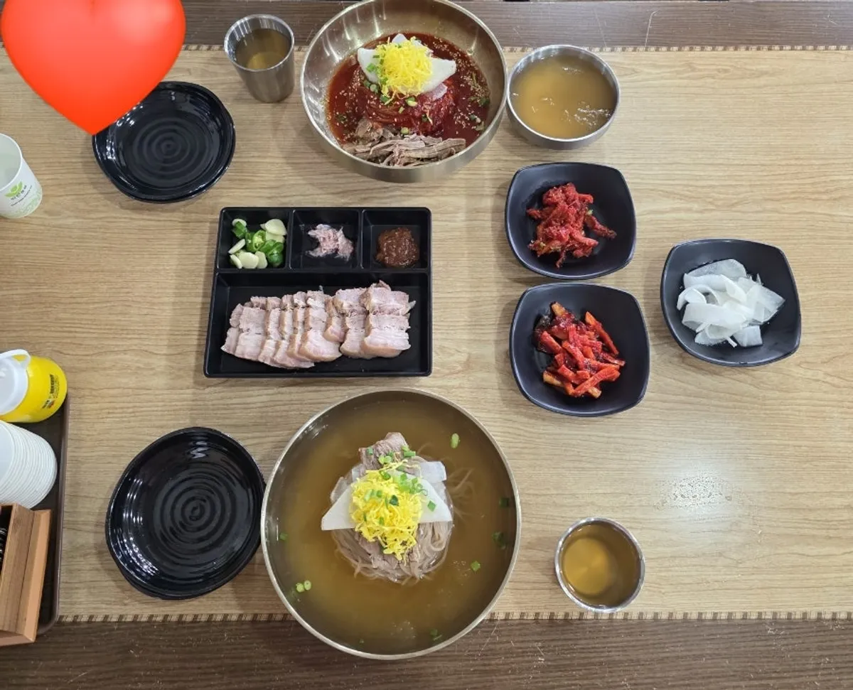 물냉면 비빔냉면 수육 반접시가 차려진 한 상