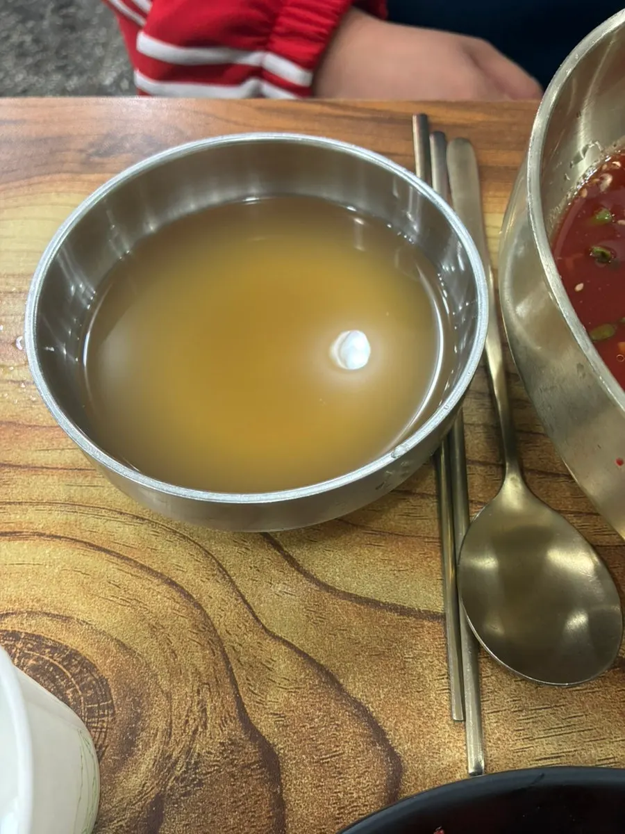 Bibim naengmyeon topped with meat, radish, and egg garnish
