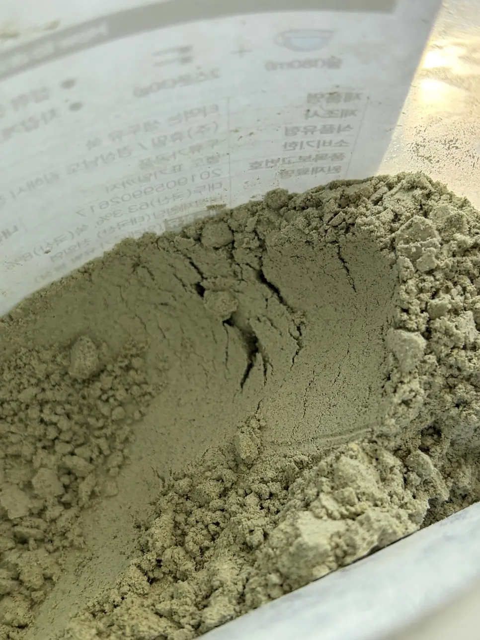 The fine mugwort soy milk powder revealed inside the opened pouch