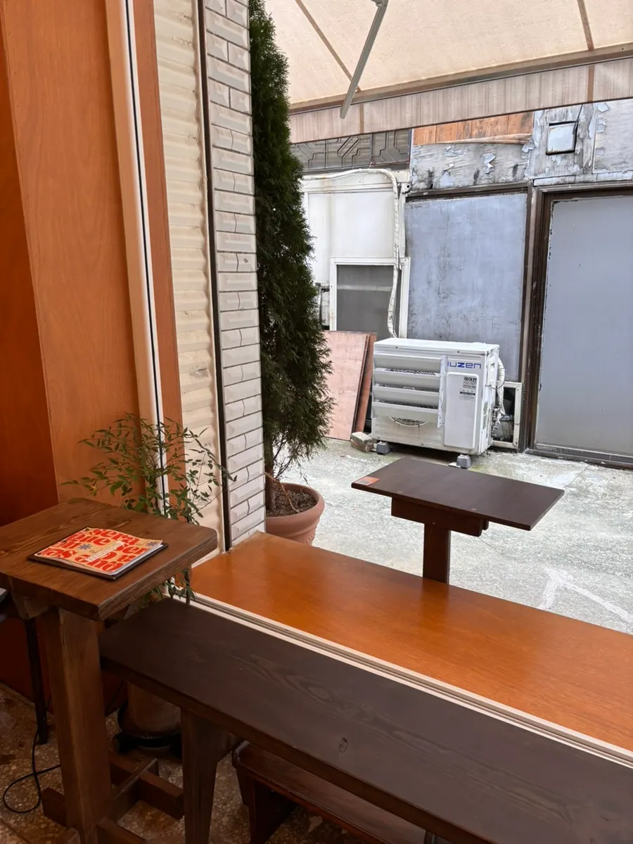 Wood-toned indoor table seating at Que Sera