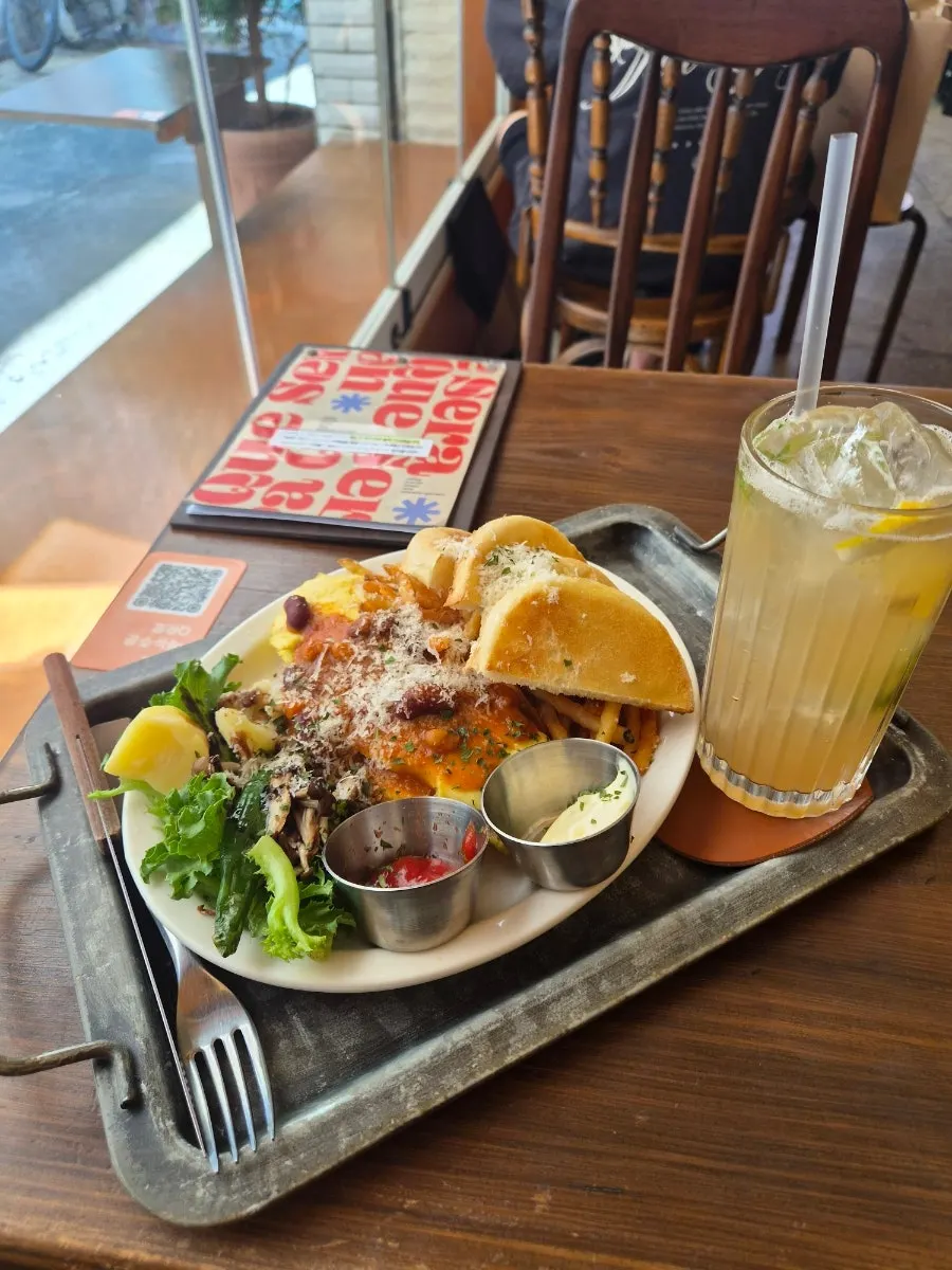 Table spread of Que Sera's omelette plate, carrot rapé, and lychee refresher ade