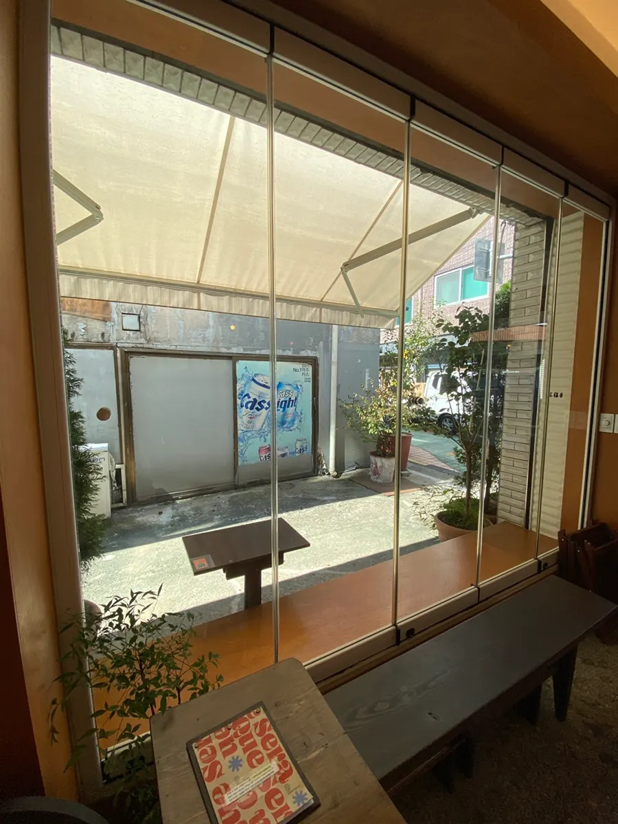 Indoor seating by the floor-to-ceiling window with sunlight coming in