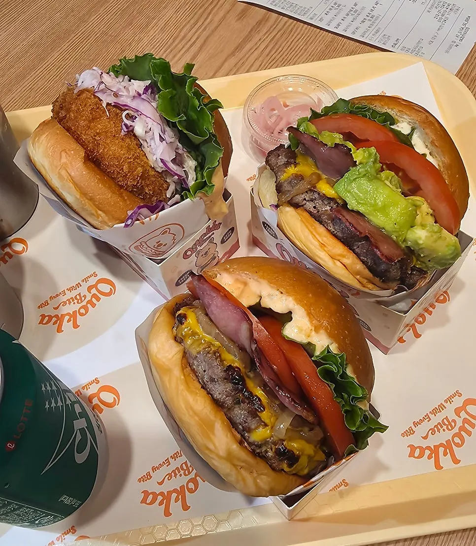 테이블에 차려진 쿼카바이트 버거 세트 세 가지