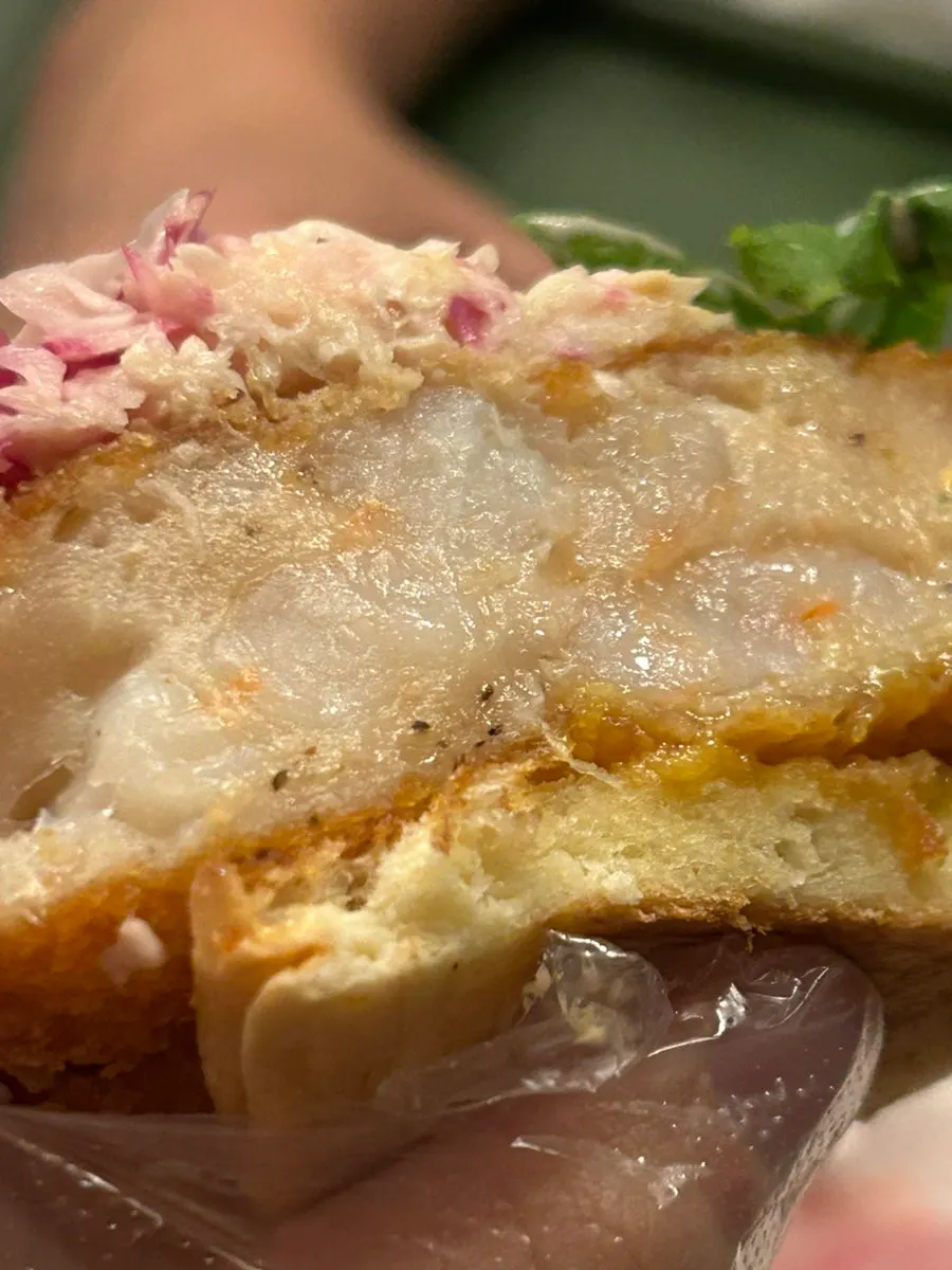 Cross-section of the shrimp burger showing coleslaw and dill pickle