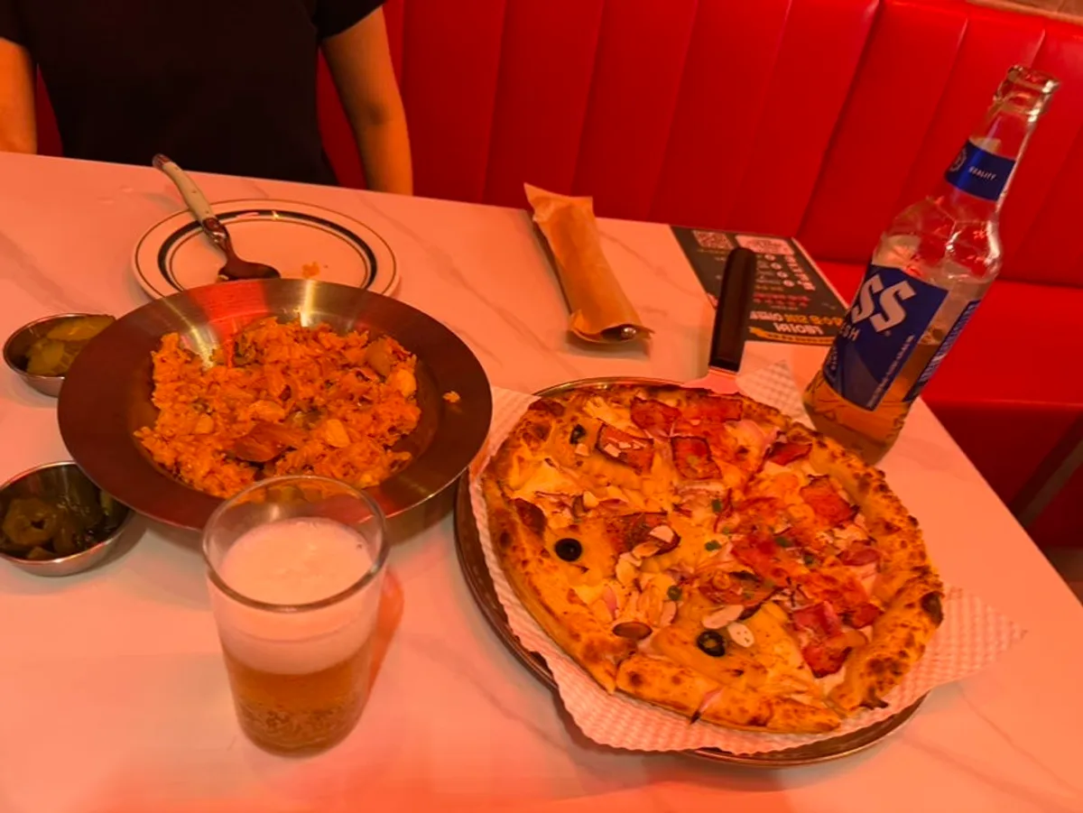 Half-and-half pizza and draft beer spread at Raccoon Pizza Mapo Station branch