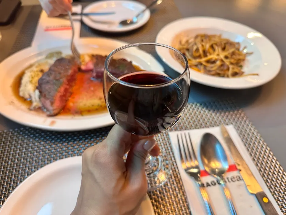 Ragu pasta served alongside red wine