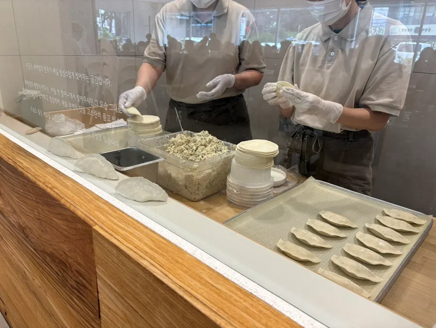 The mandu-making workspace visible behind glass