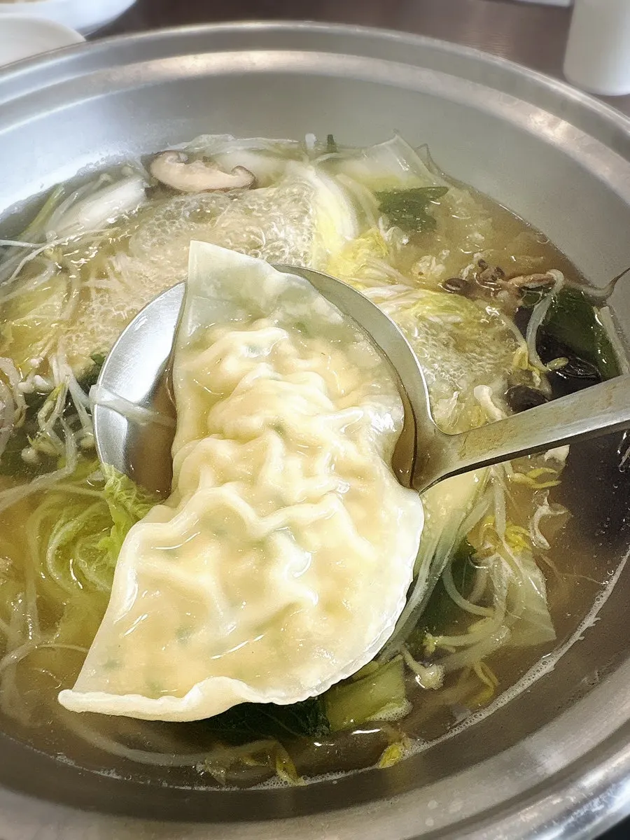 A large Pyeongyang mandu lifted out with a ladle