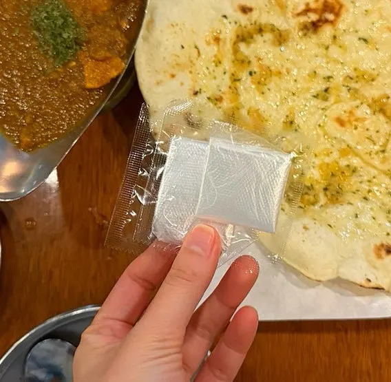 Plastic gloves provided for eating the naan