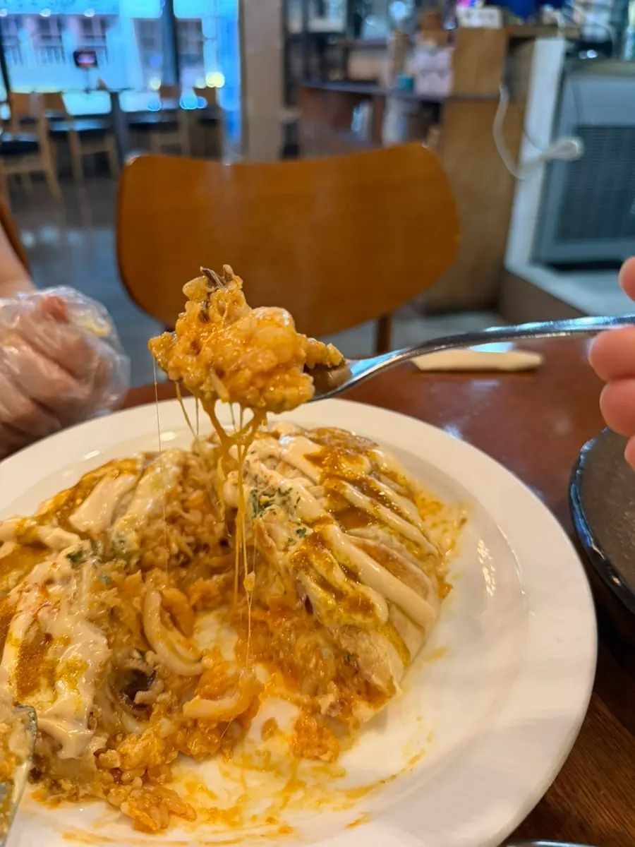 Cross-section of nasi goreng with stretchy melted cheese