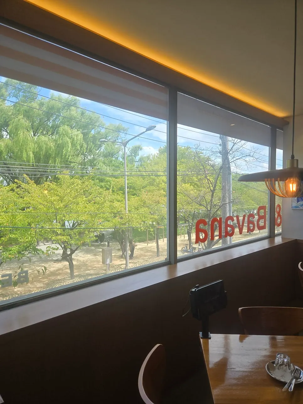 Picture window with trees around Suseong Lake in view