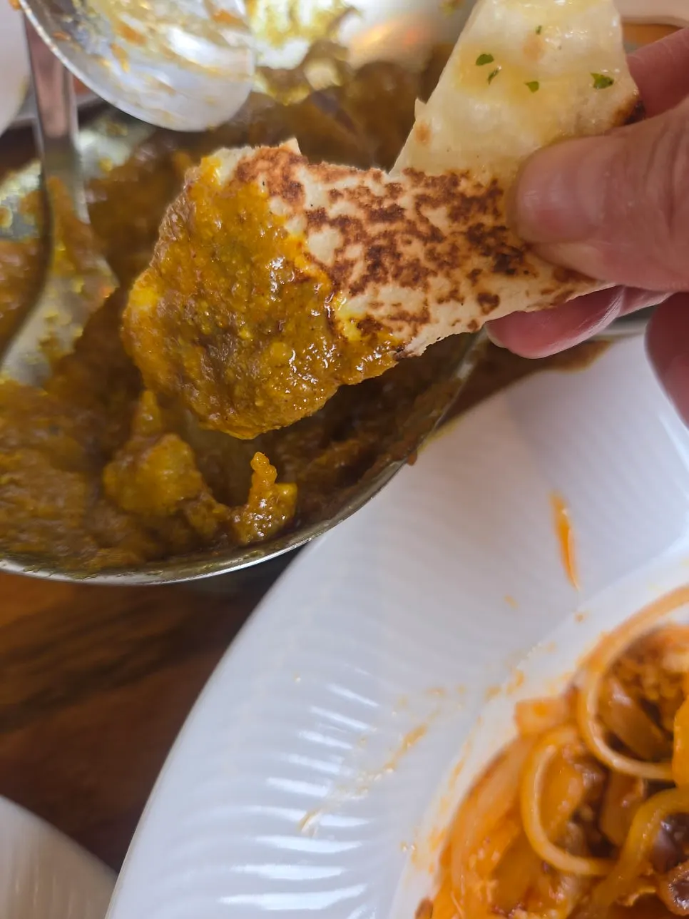Table setting with garlic naan and beef curry together