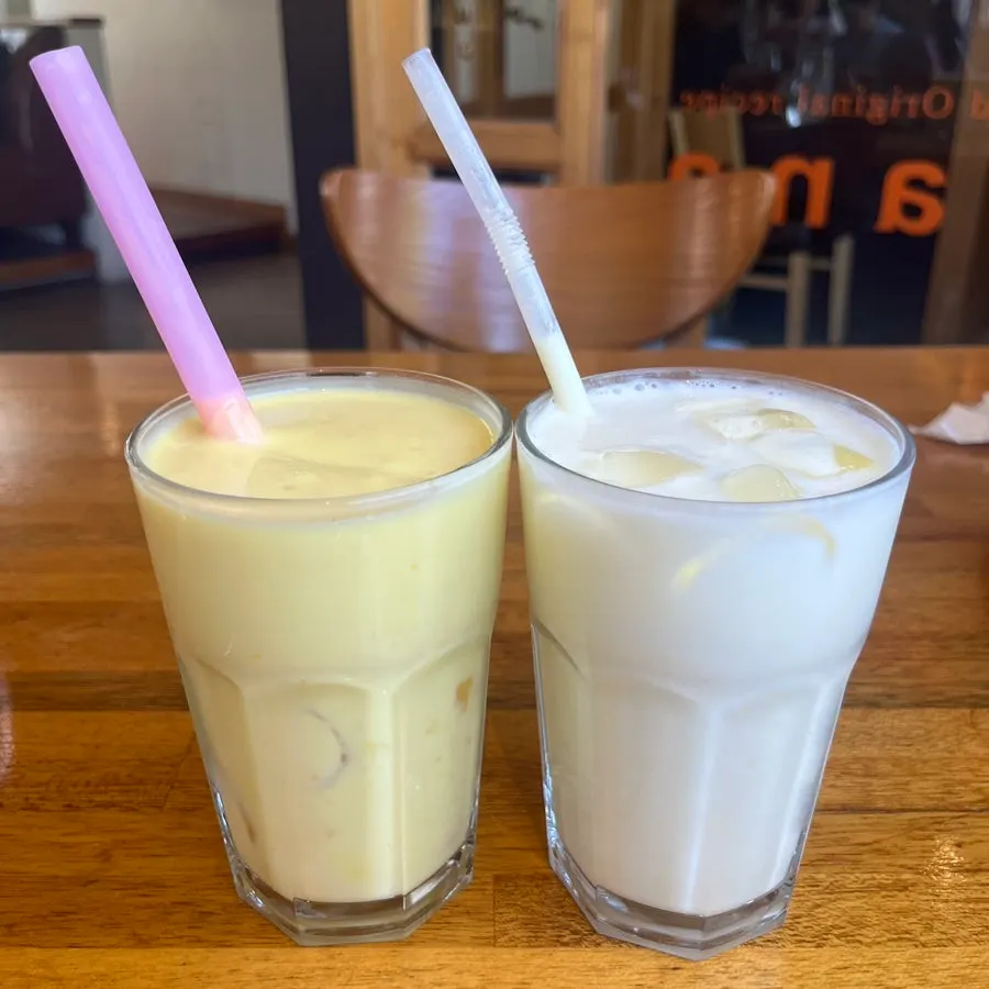 Two glasses of pineapple and mango lassi