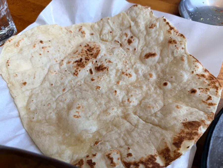 Large naan served alongside the curry