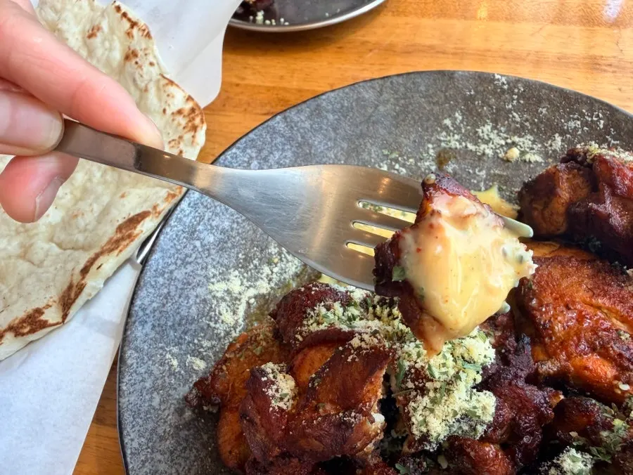 A piece of tandoori cream chicken picked up by hand