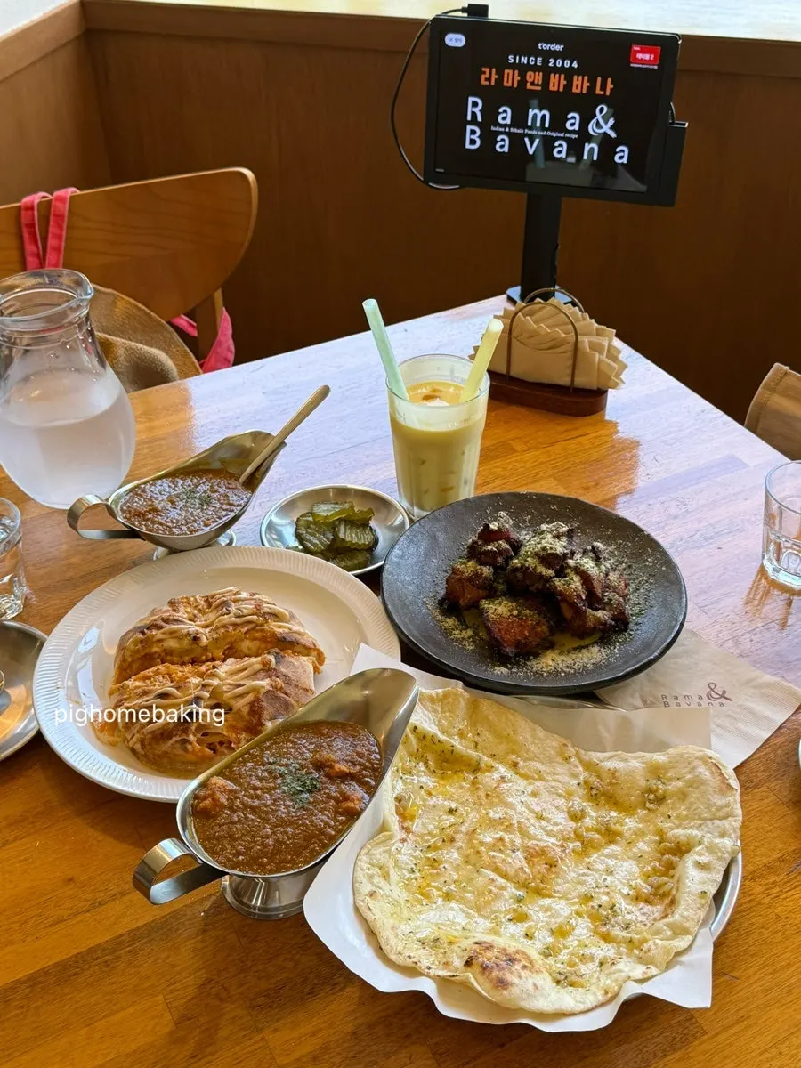 Full table spread of nasi goreng, chicken curry, tandoori chicken and naan