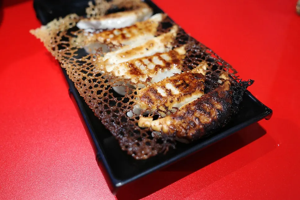 A plate of Japanese-style gyoza, crispy on one side