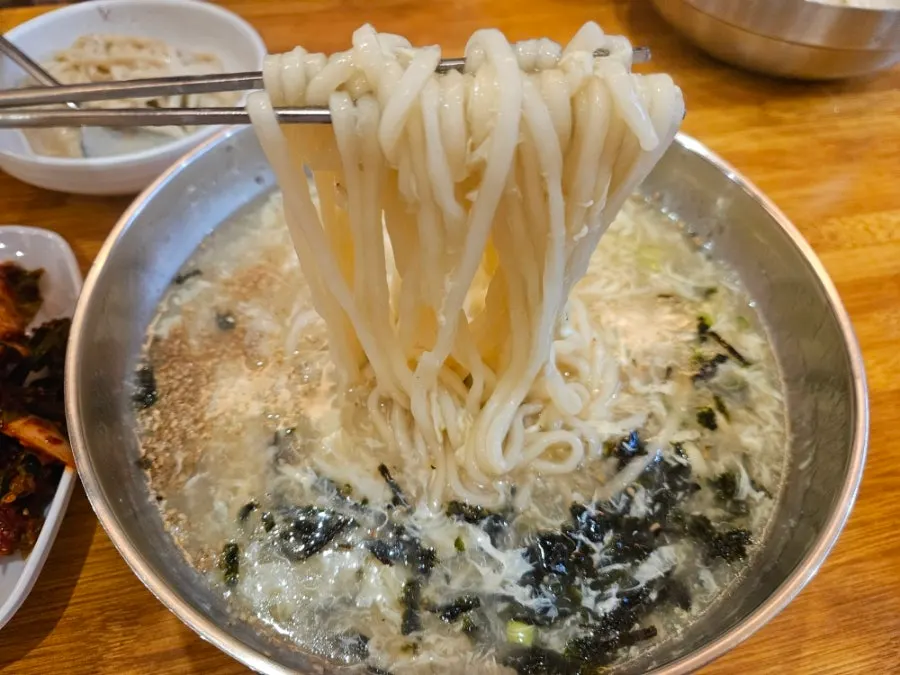 Close-up of kalguksu noodles topped with perilla oil
