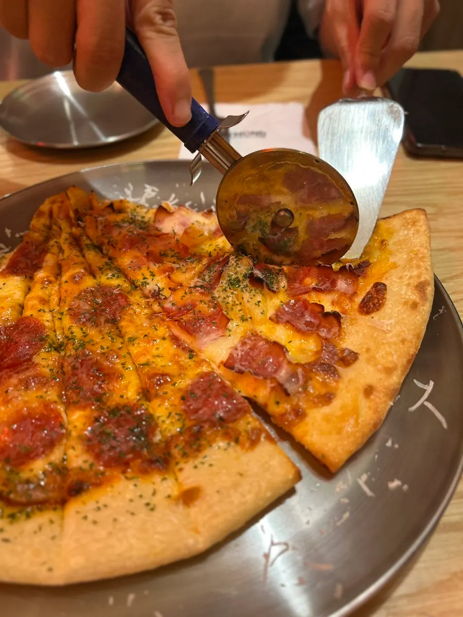 A giant beer mug next to a giant pizza slice on the table