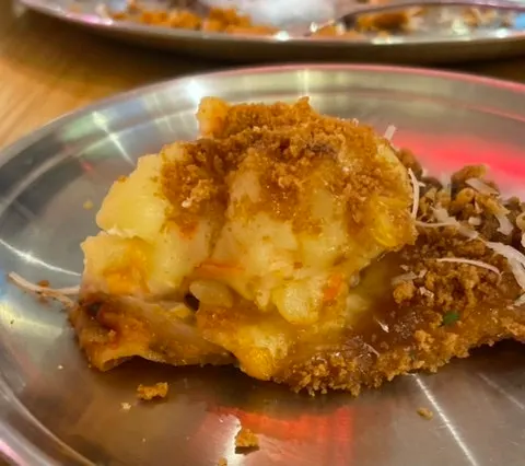 A pizza plate topped with scoops of potato salad
