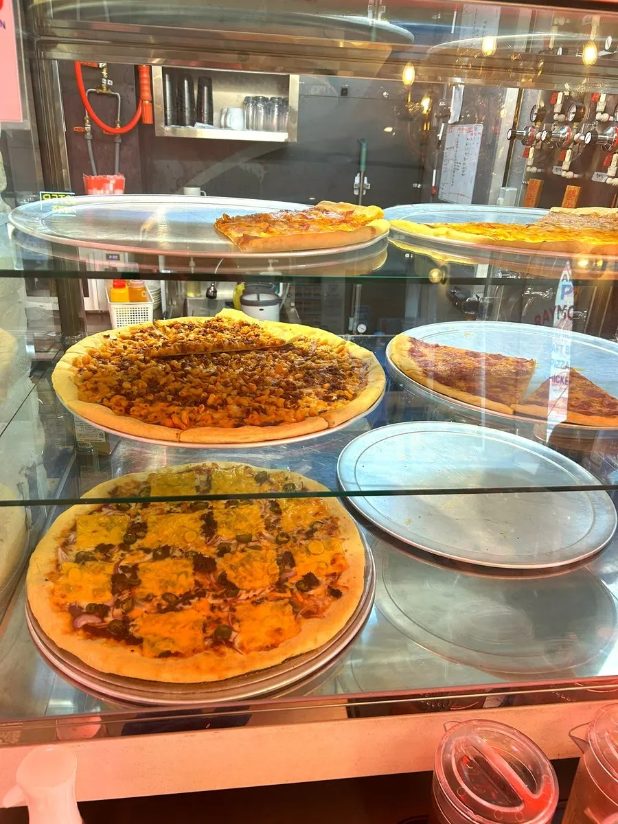 Sign listing American-style slice pizza varieties