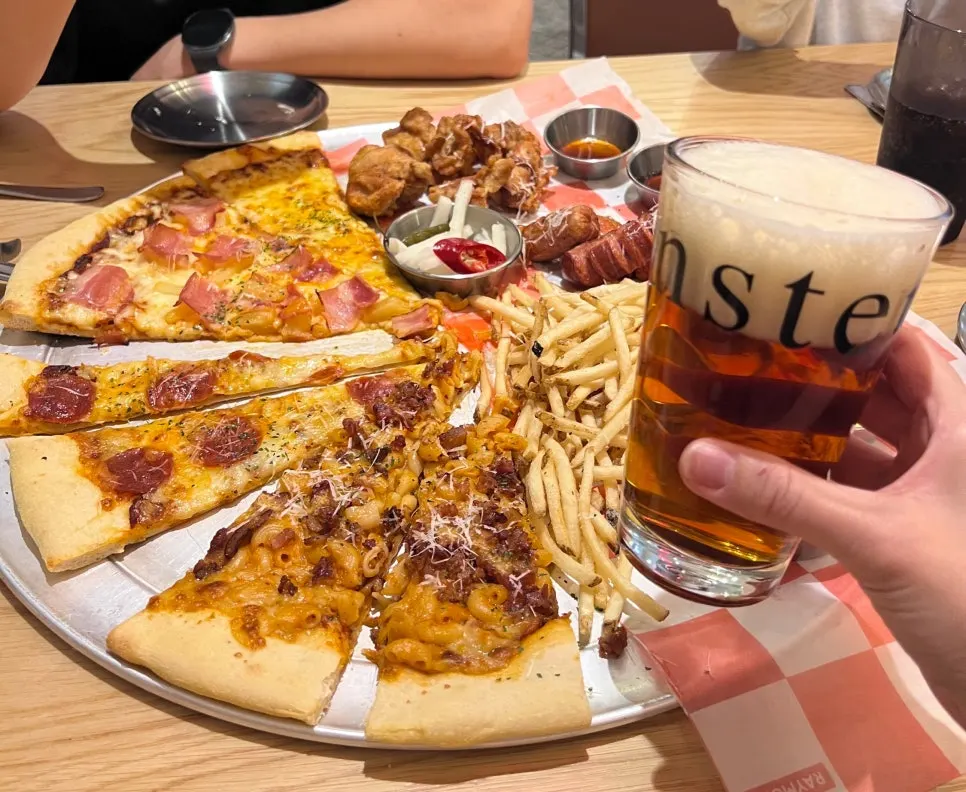 Craft beer set down next to the slice pizza