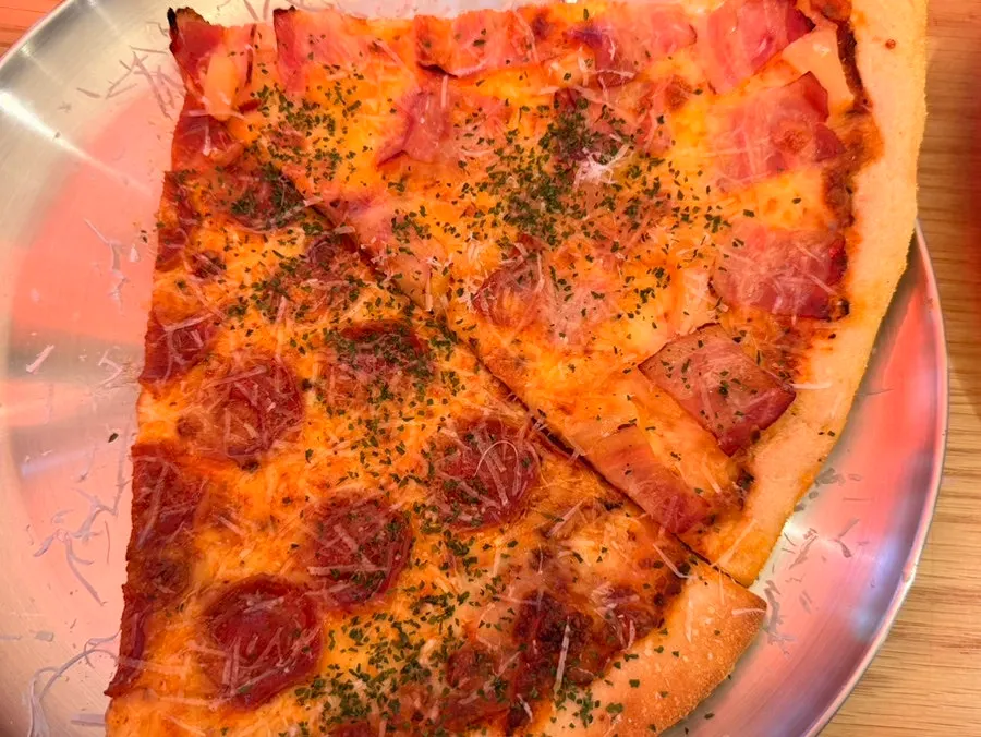 Two slices of pepperoni and bacon Hawaiian pizza