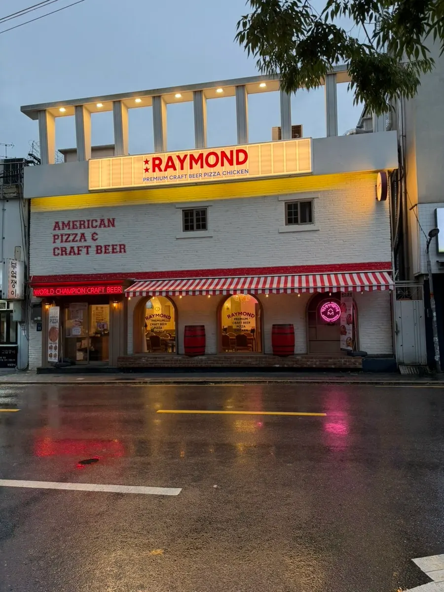 Palm trees and a red awning at the exterior of Raymond Isu Branch