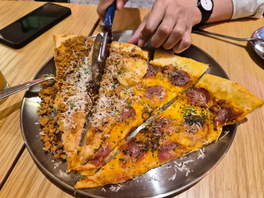 Slice pizza cut in half with a knife
