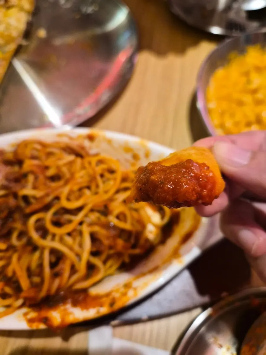 Dipping the pizza crust end into mac and cheese