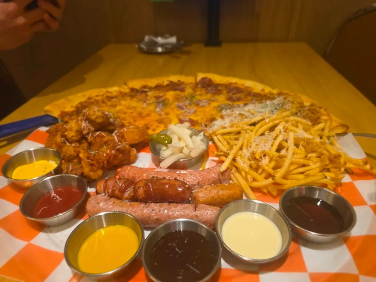 Table with pizza and beer under the chandelier at Raymond Isu Branch