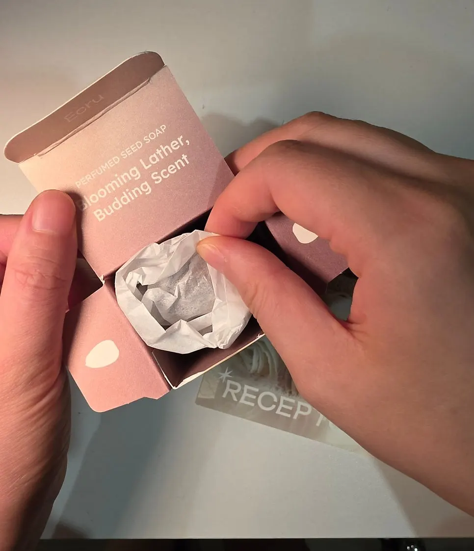 Holding the unwrapped Ecru seed soap