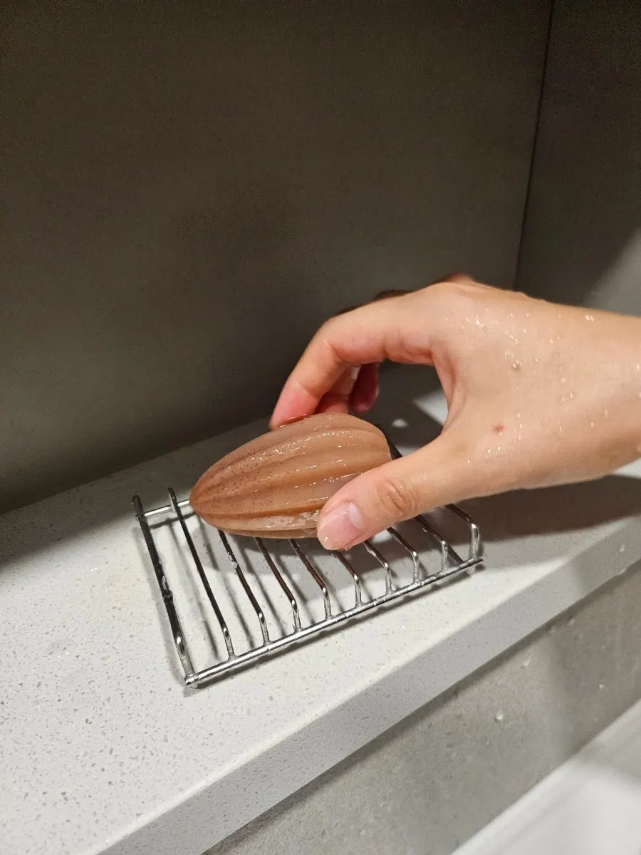 Seed-shaped scrub soap in use for washing