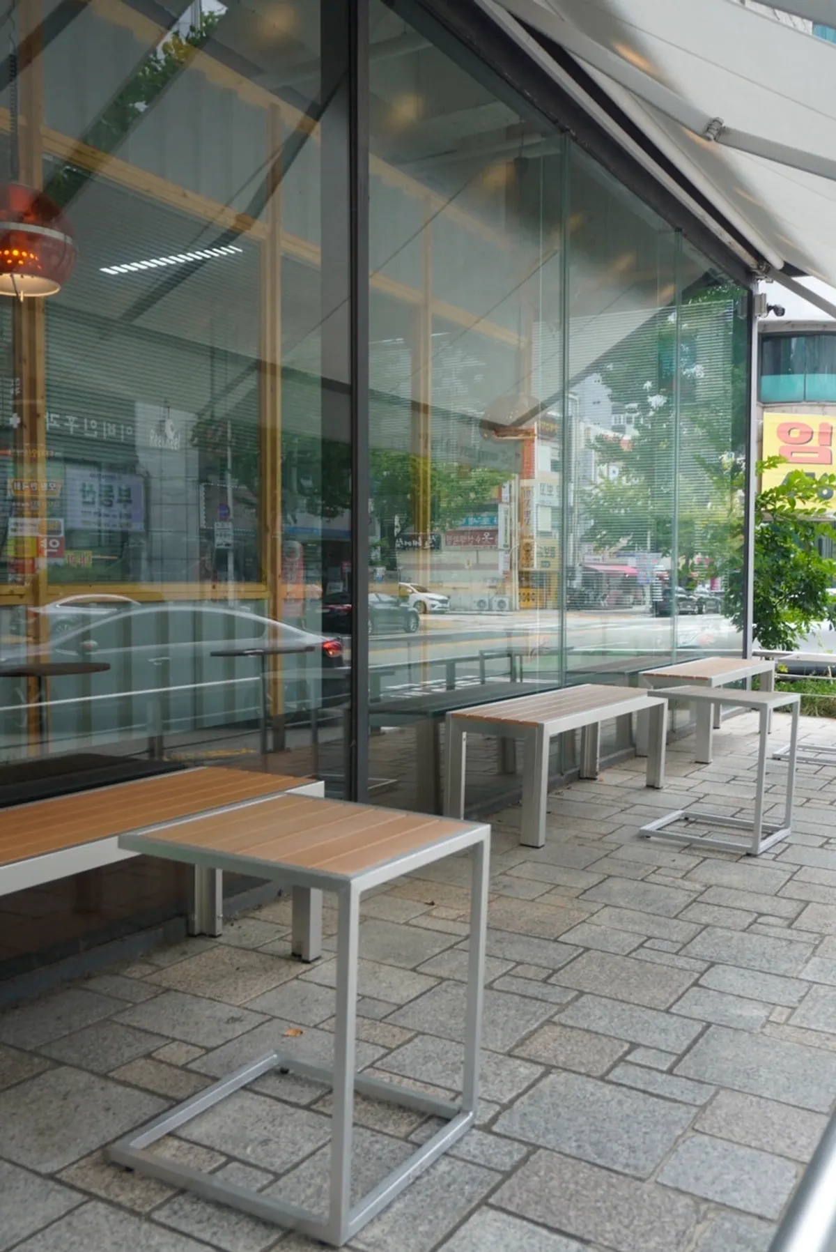 Reelbakers entrance with floor-to-ceiling windows and terrace tables