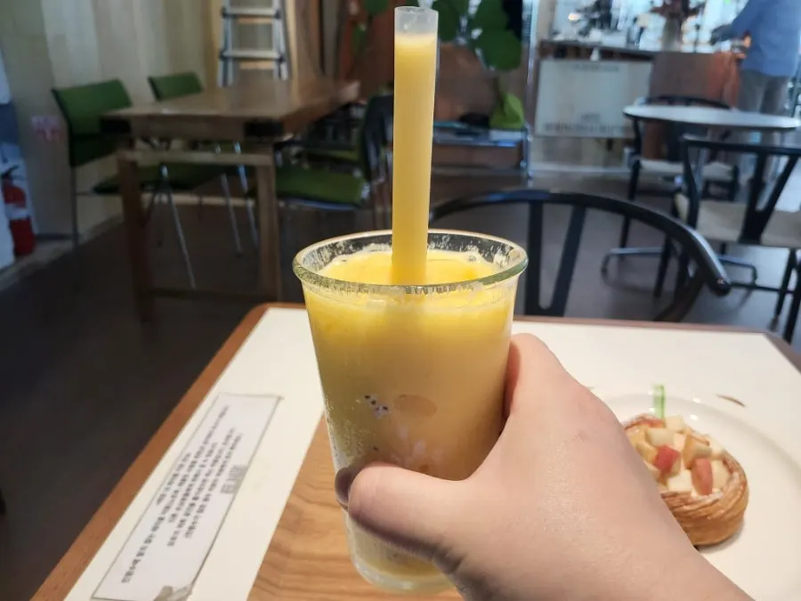 Yellow mango smoothie and dessert table setting