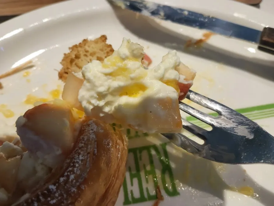 A bite of fruit cream pastry lifted with a fork