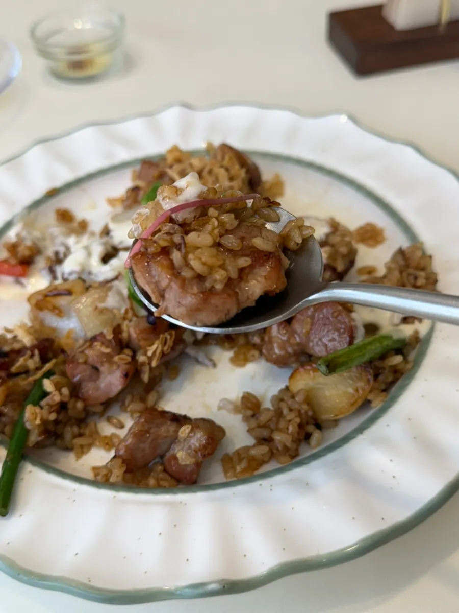 A spoonful of pilaf with big chunks of pork