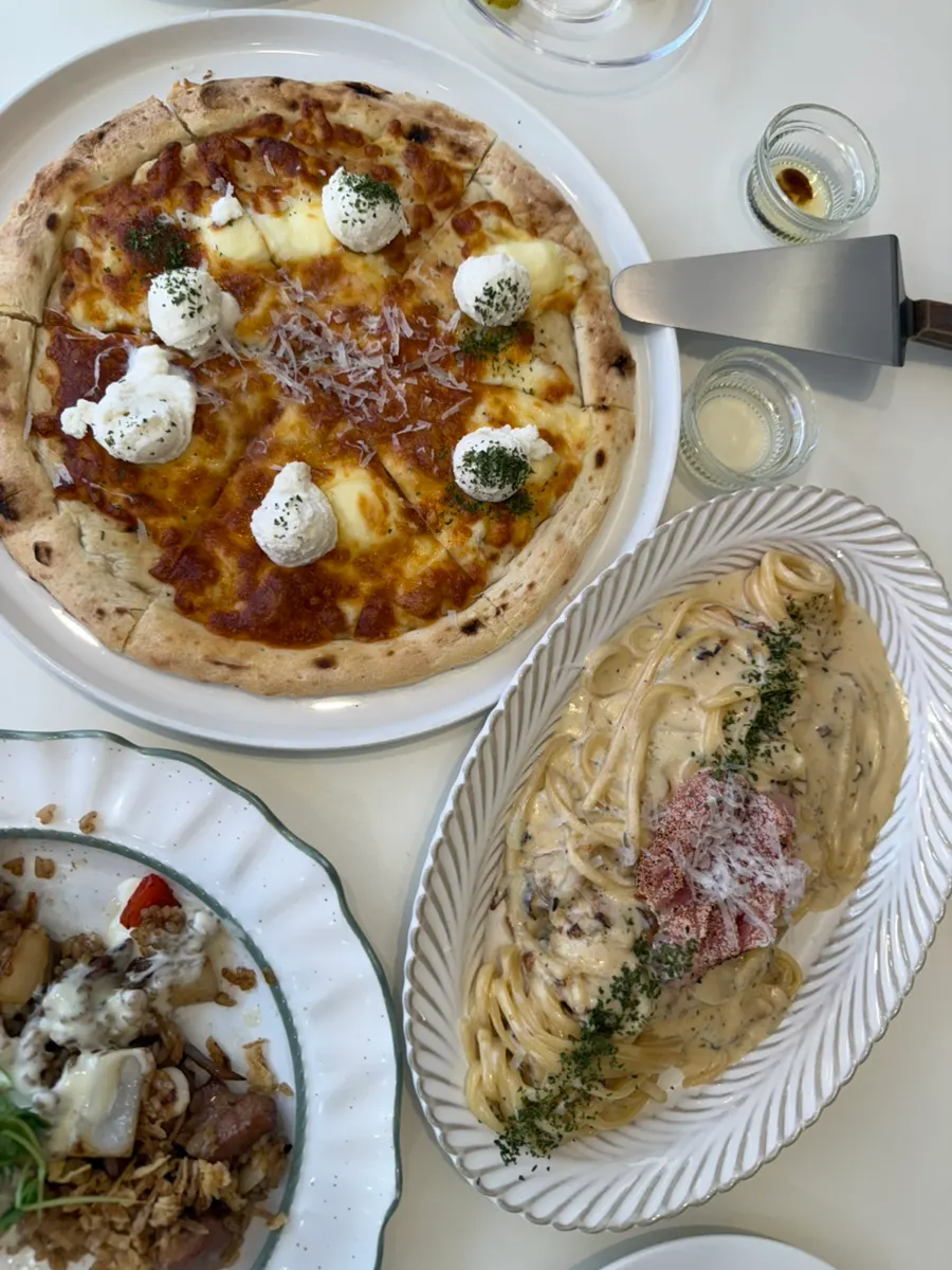 Table with roe cream pasta and pizza together