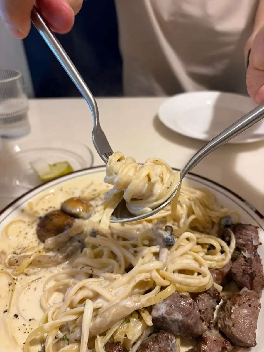 Cream pasta noodles lifted with a fork