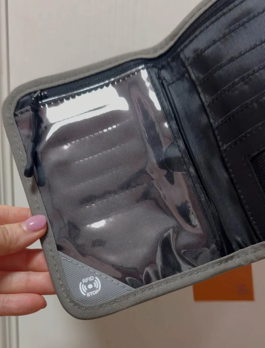 Passport bag holding a passport and payment methods together