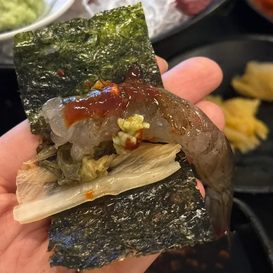 A firm, chewy piece of raw shrimp sashimi