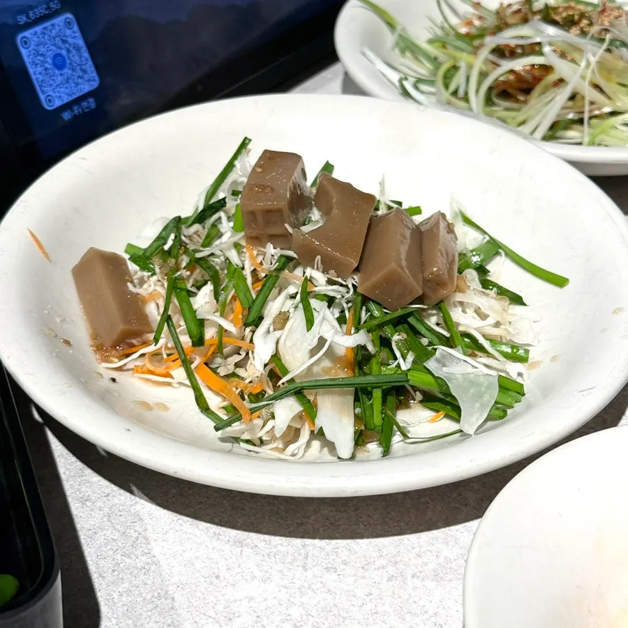 Shredded scallions and other side dishes served with the meat