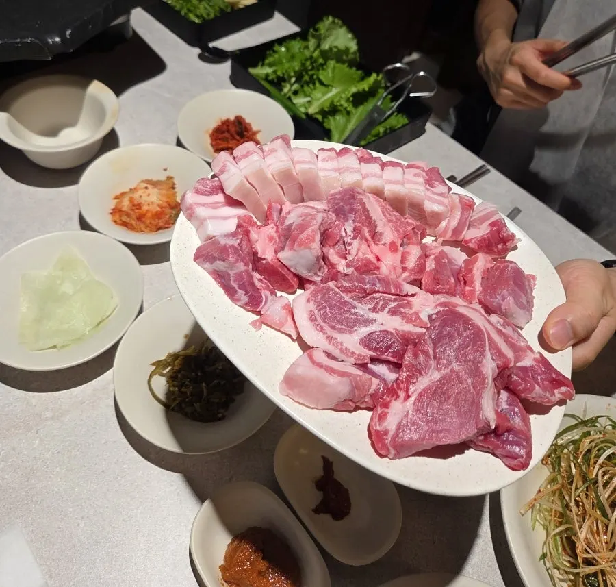 Plate of raw pork belly, pork neck, and special cut