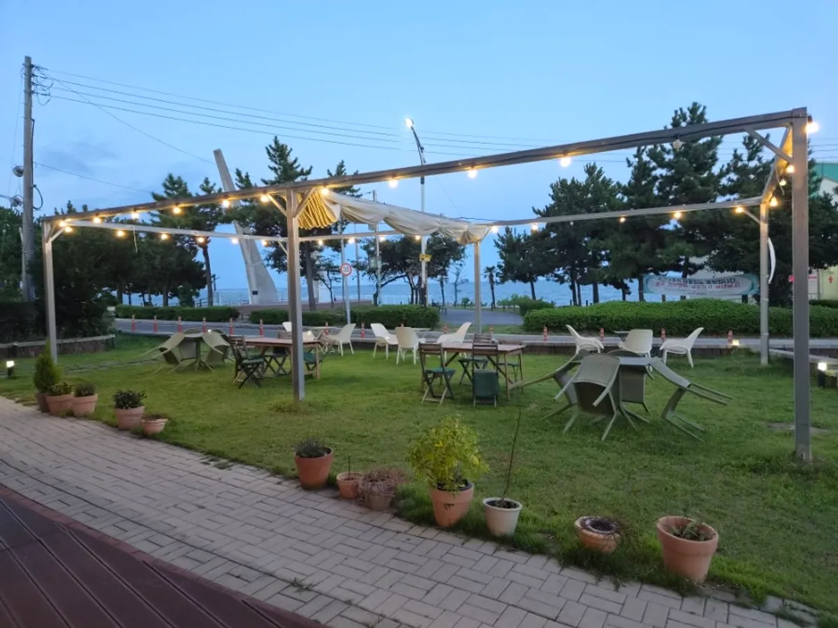 View of Riverside with lawn outdoor tables and the sea beyond