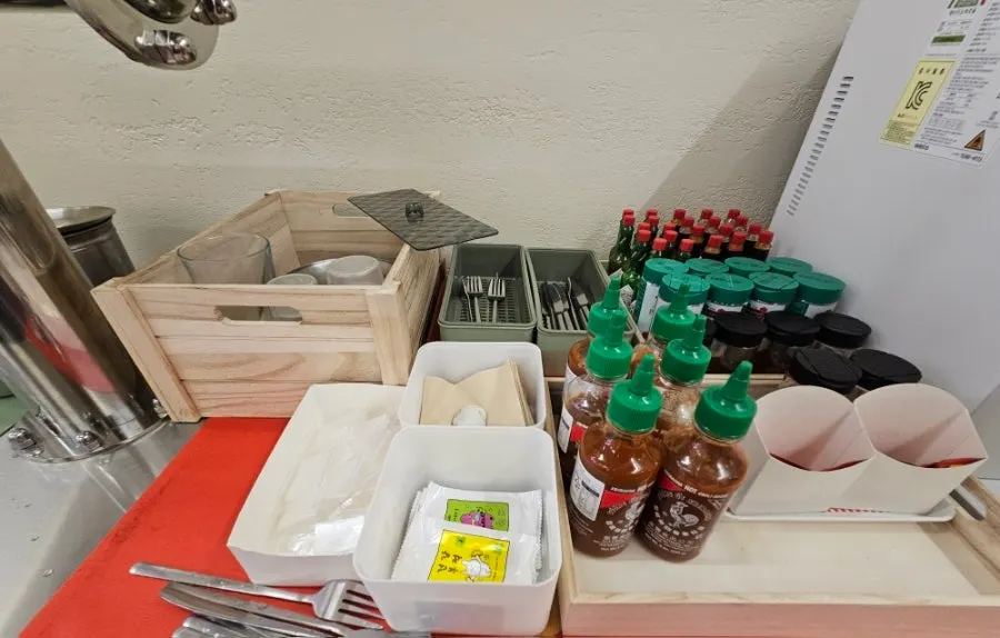 Self-service corner with water, napkins, and sauces