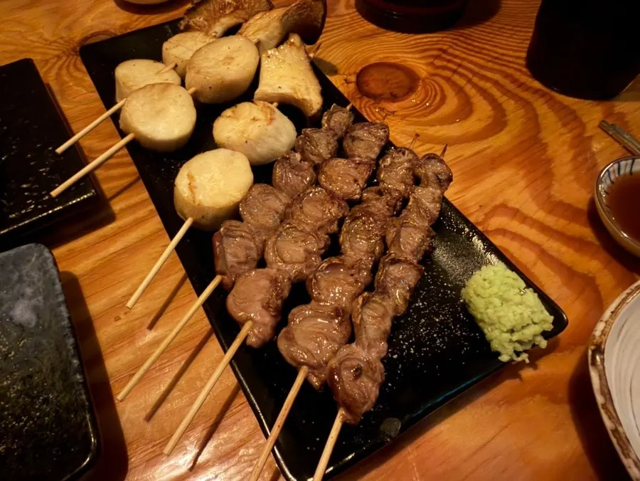 Table setting with chicken heart skewer and mushroom skewer together