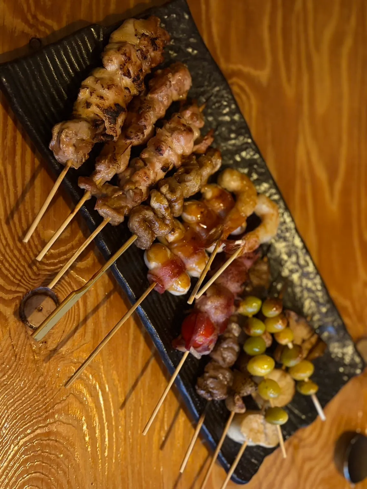 Vertical photo of sashimi and skewers at the Guro izakaya