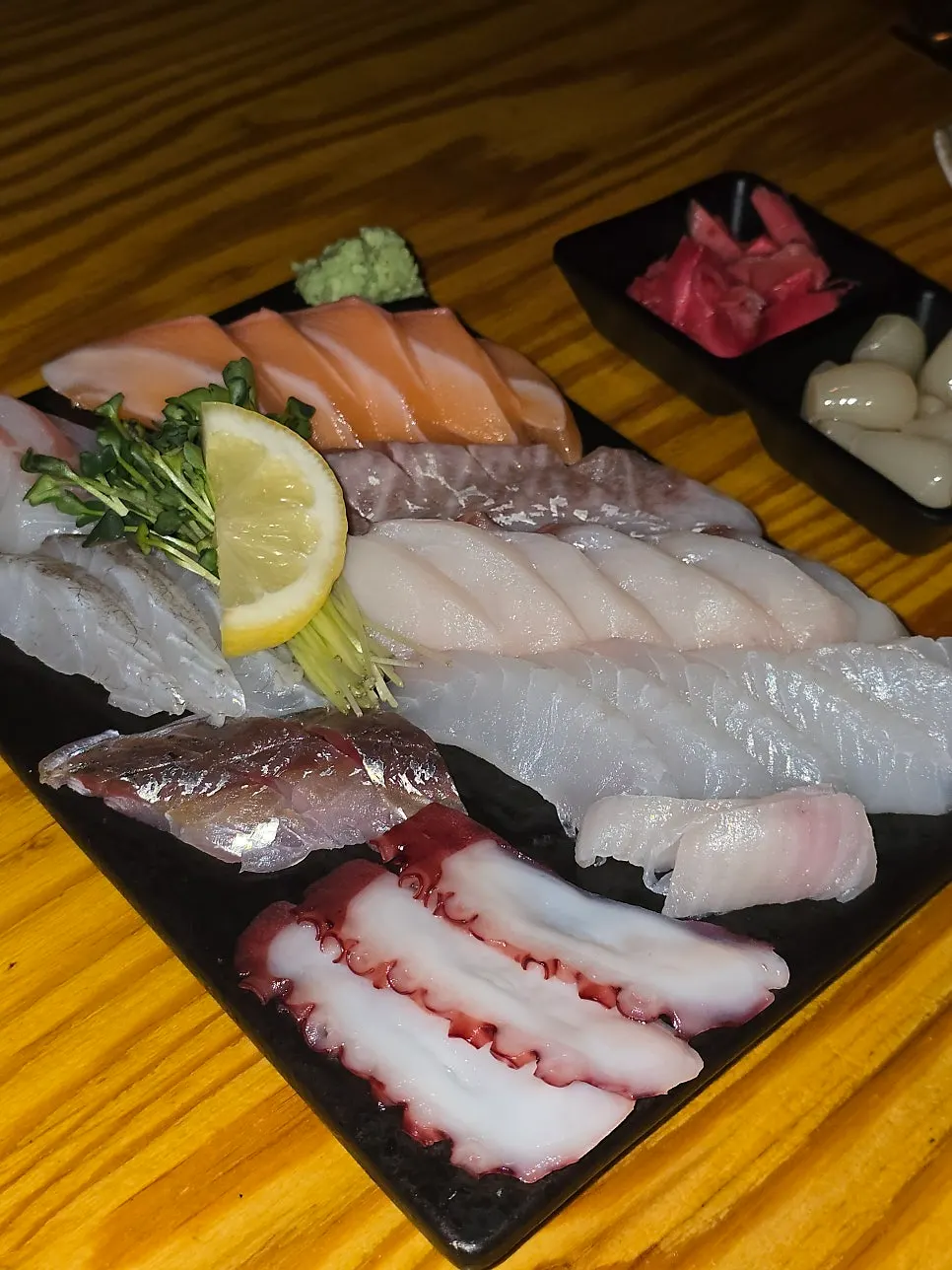 刺身を一切れ箸でつまんでいる様子