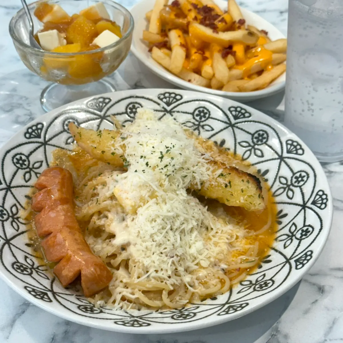 Solo dining spread of pasta and bacon cheese fries